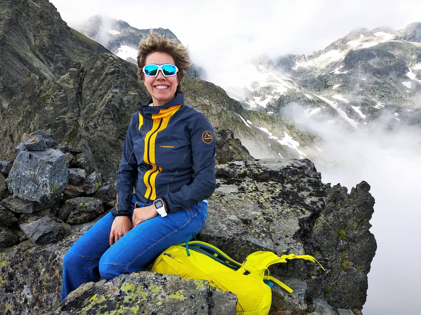 Carme en una cumbre del Pirineu, niebla envolviendo la cordillera